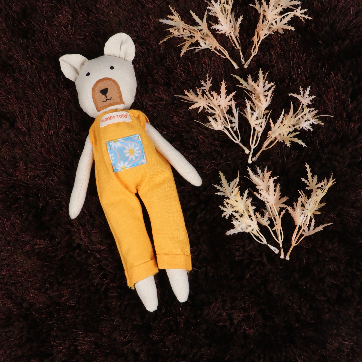 12 inch soft fabric bear doll lying on brown rug wearing pastel orange colored outfit, ideal for toddlers and young children