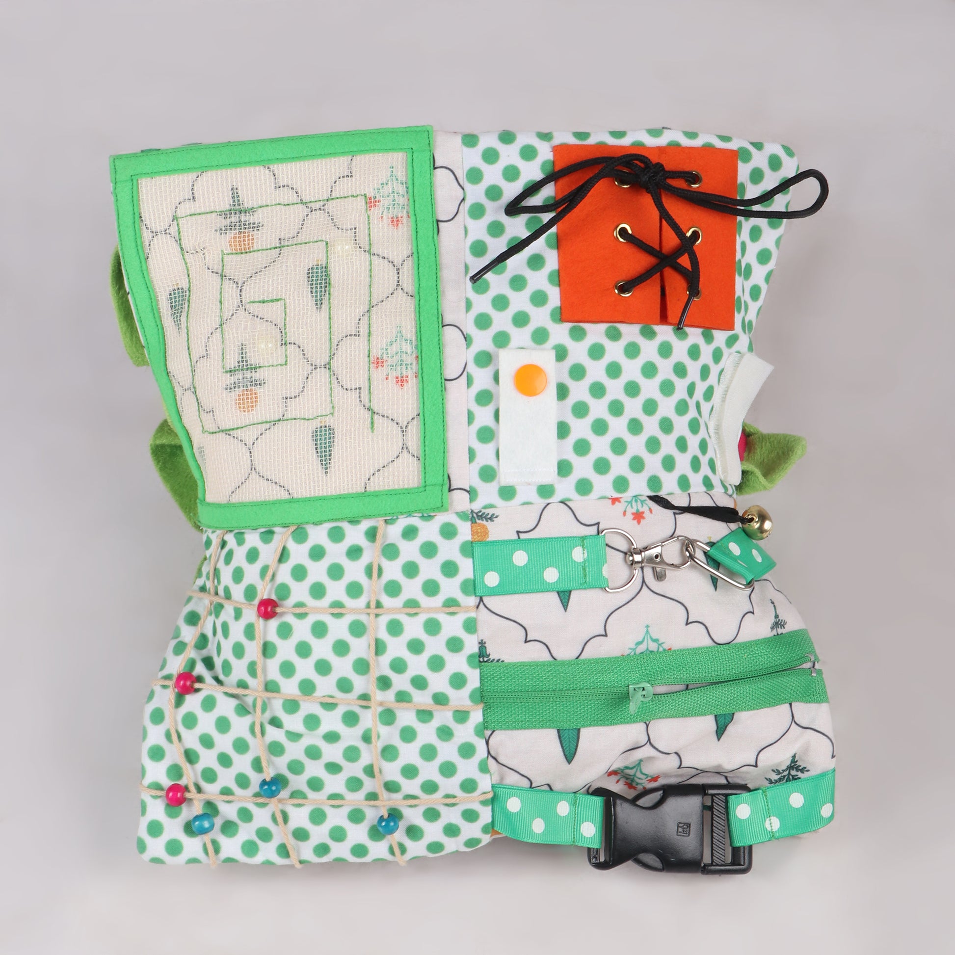 Close up of Sensory fidget blanket with different textures, zippers, and buttons, buckles, button maze with net, push button and Velcro and shoe lace pattern, great for tactile stimulation and calm play