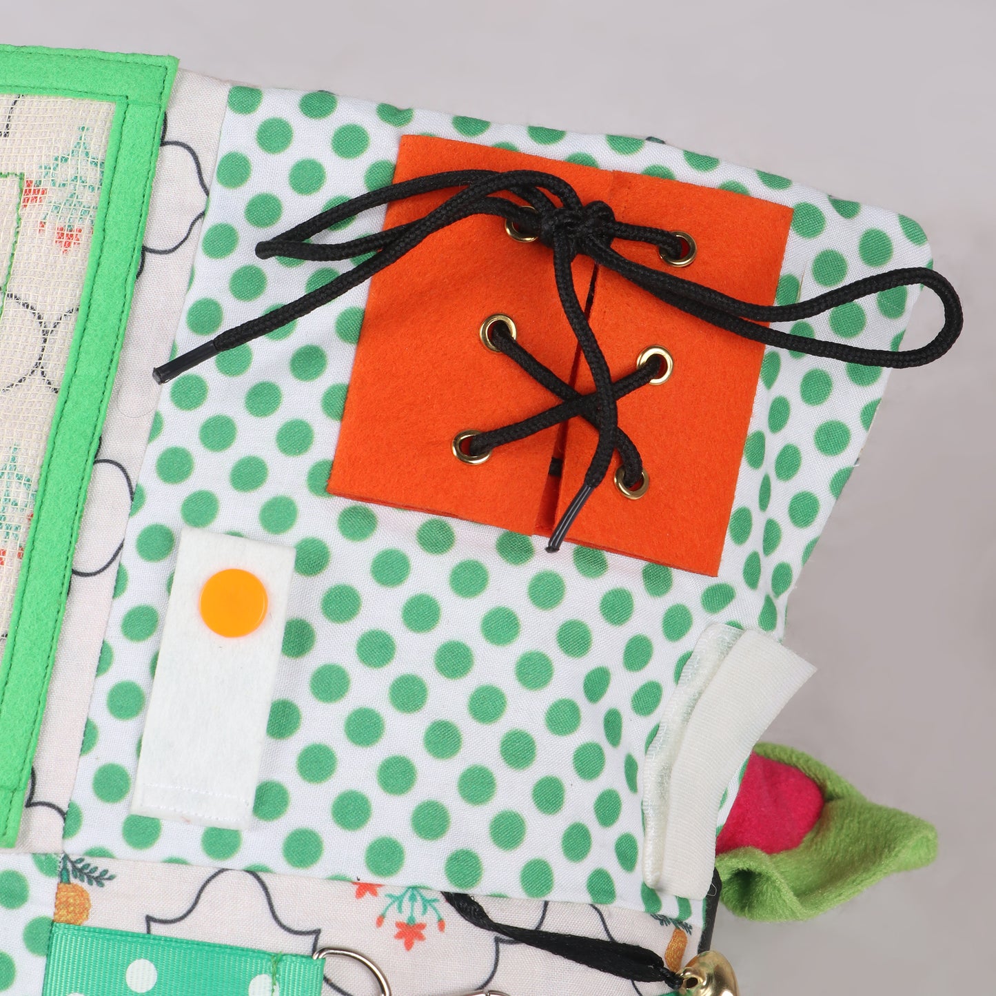 Close up of shoe lace activity, push button and Velcro activity on sensory fidget blanket for tactile stimulation and calm play