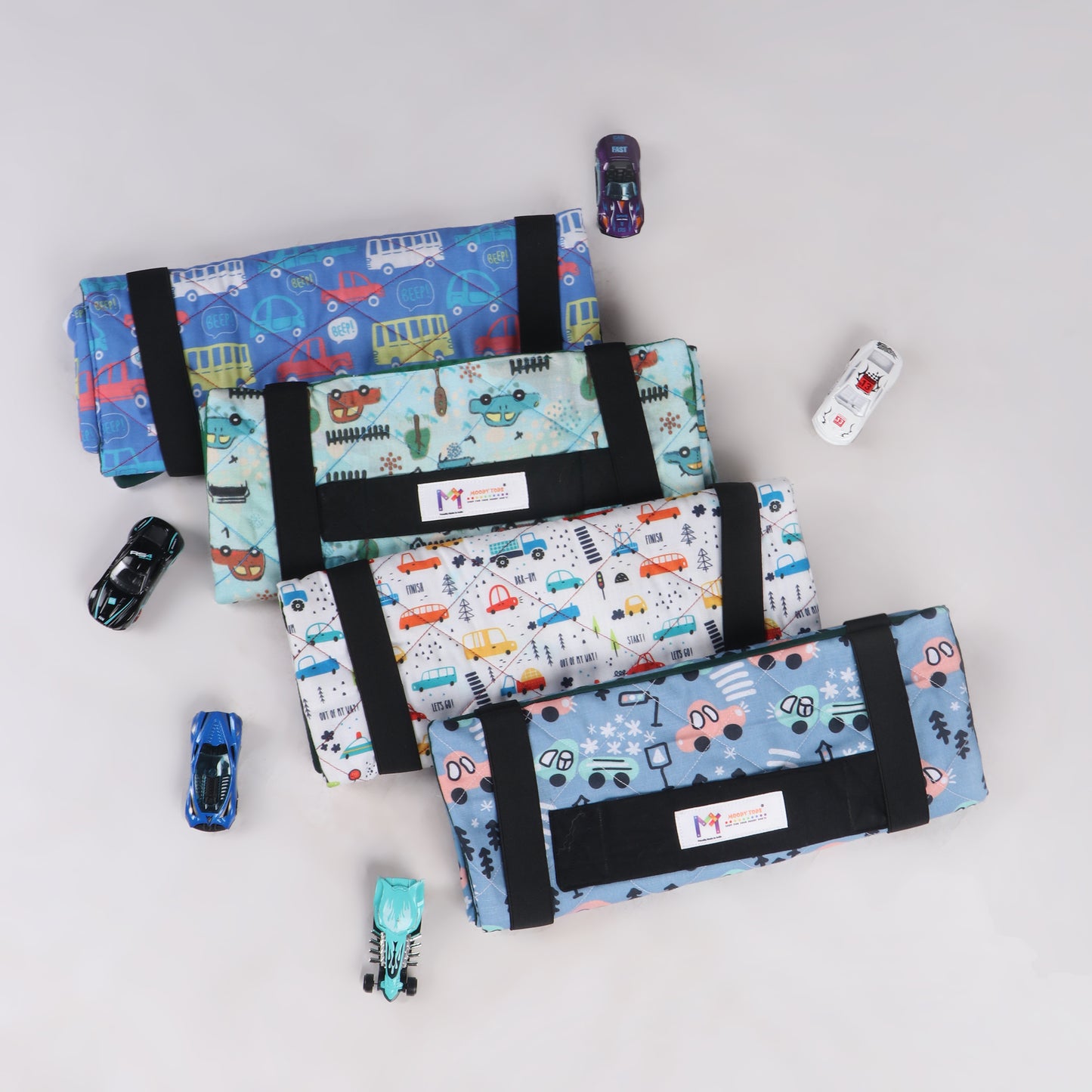 4 Portable fabric car playmat in different color with car print in folded position designed for interactive play on the go