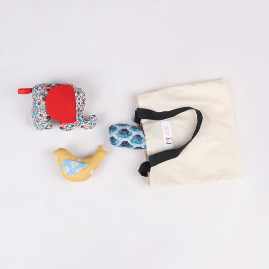 Elephant, Bird and Shark-shaped sensory taggie toy coming out of its fabric bag for tactile exploration and comfort.