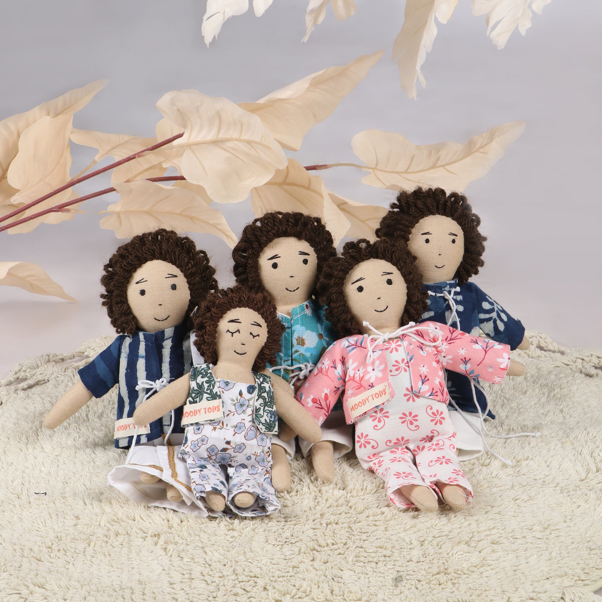 Cute 9 inch handmade fabric boy rag doll in men outfit made from child-safe, soft fabric, and in sitting position with cream colored leaves behind them