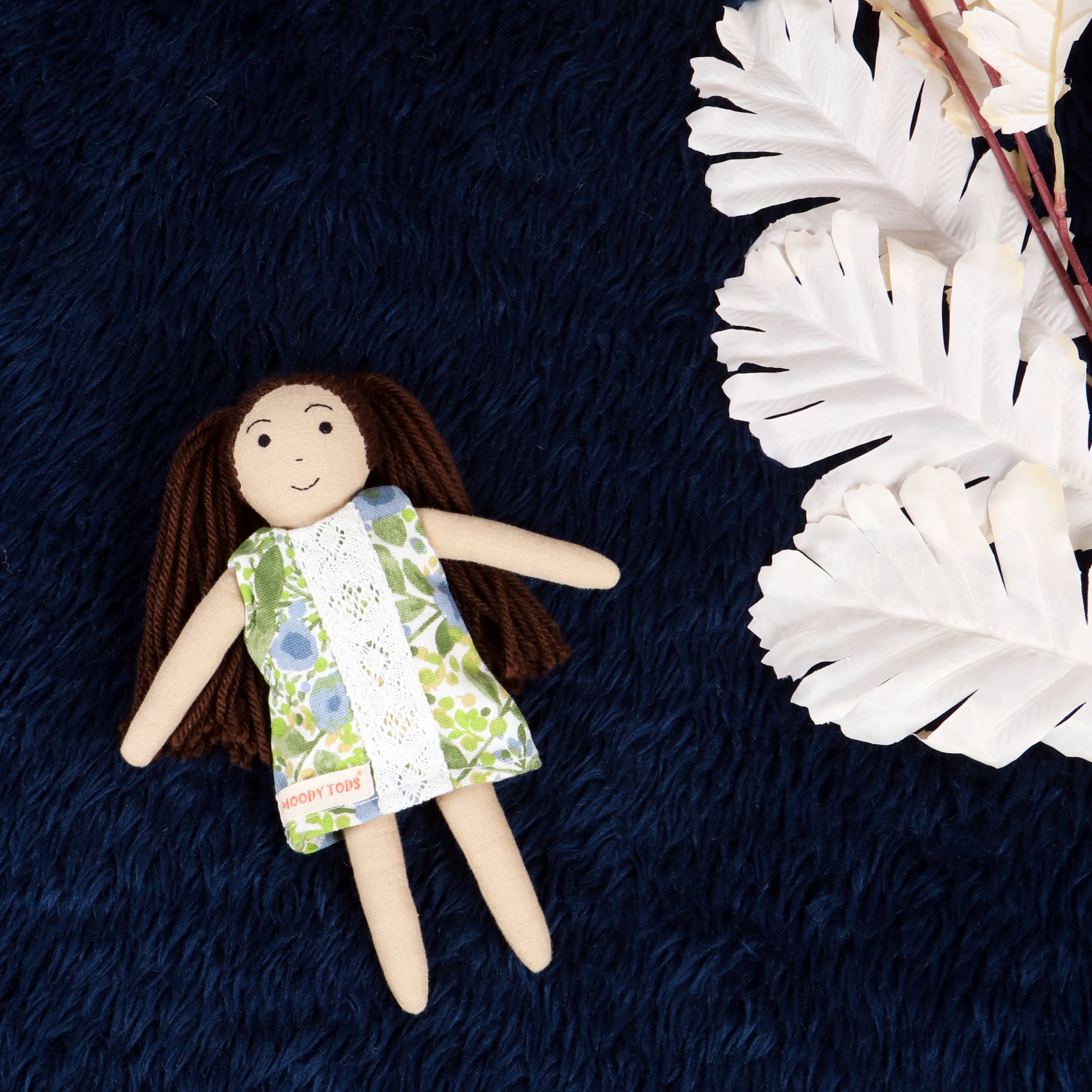 Front view of handmade fabric rag doll with green floral outfit with soft, sensory-friendly material, designed for comfort and imaginative play