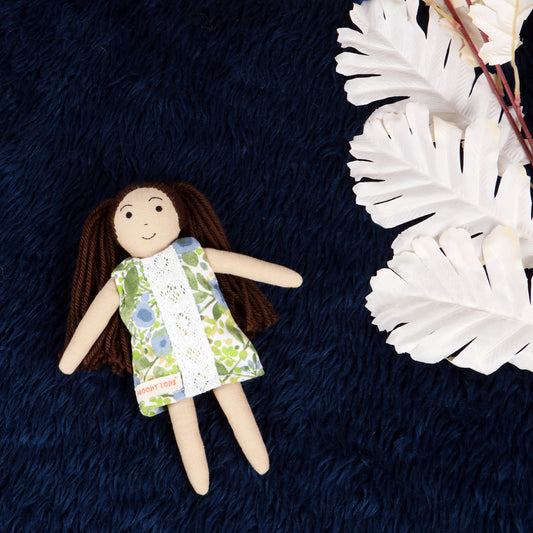 Front view of handmade fabric rag doll with green floral outfit with soft, sensory-friendly material, designed for comfort and imaginative play