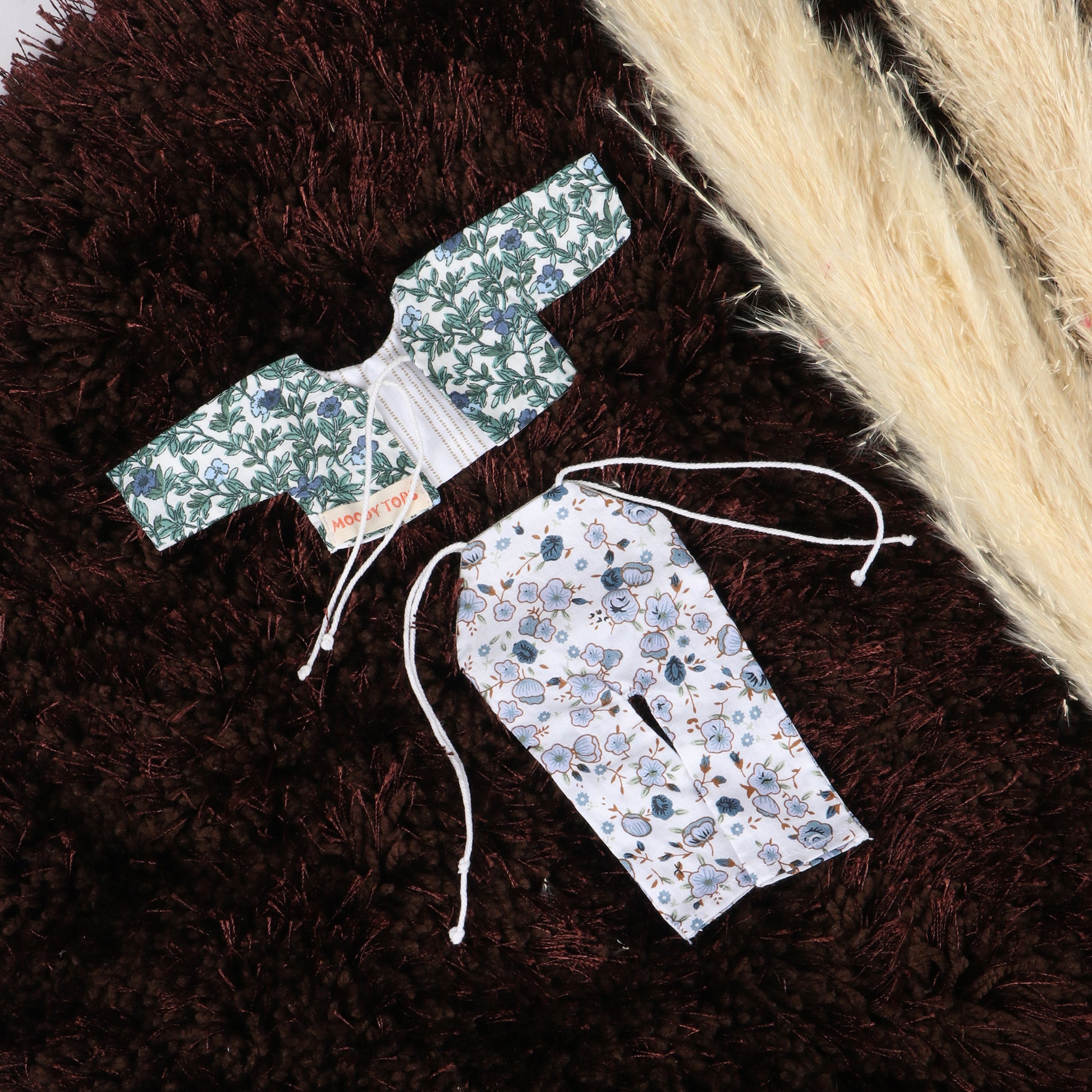 Close up of floral pattern colorful outfit for 9 inch boy rag doll made from child-safe, soft fabric