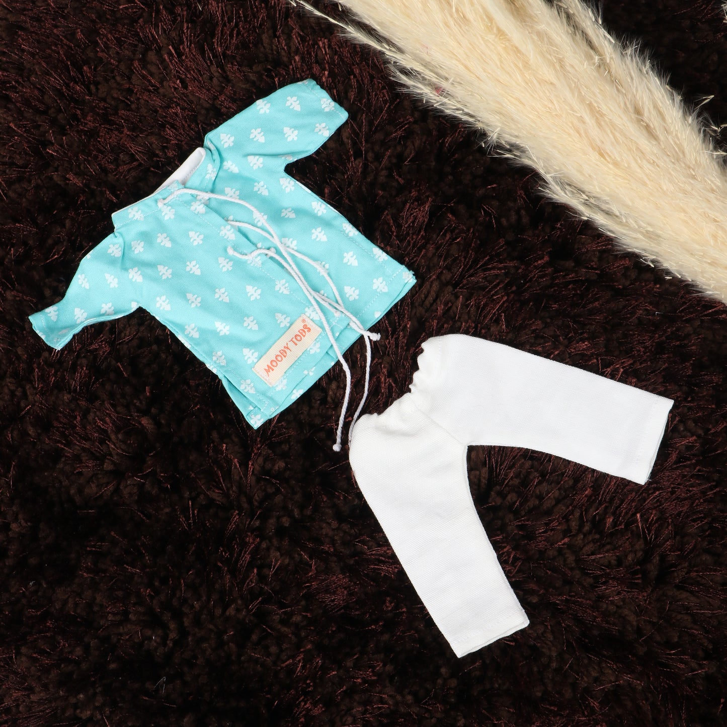 Close up view of a floral pattern shirt and white pant for 9 inch handmade fabric boy rag doll made from child-safe, soft fabric
