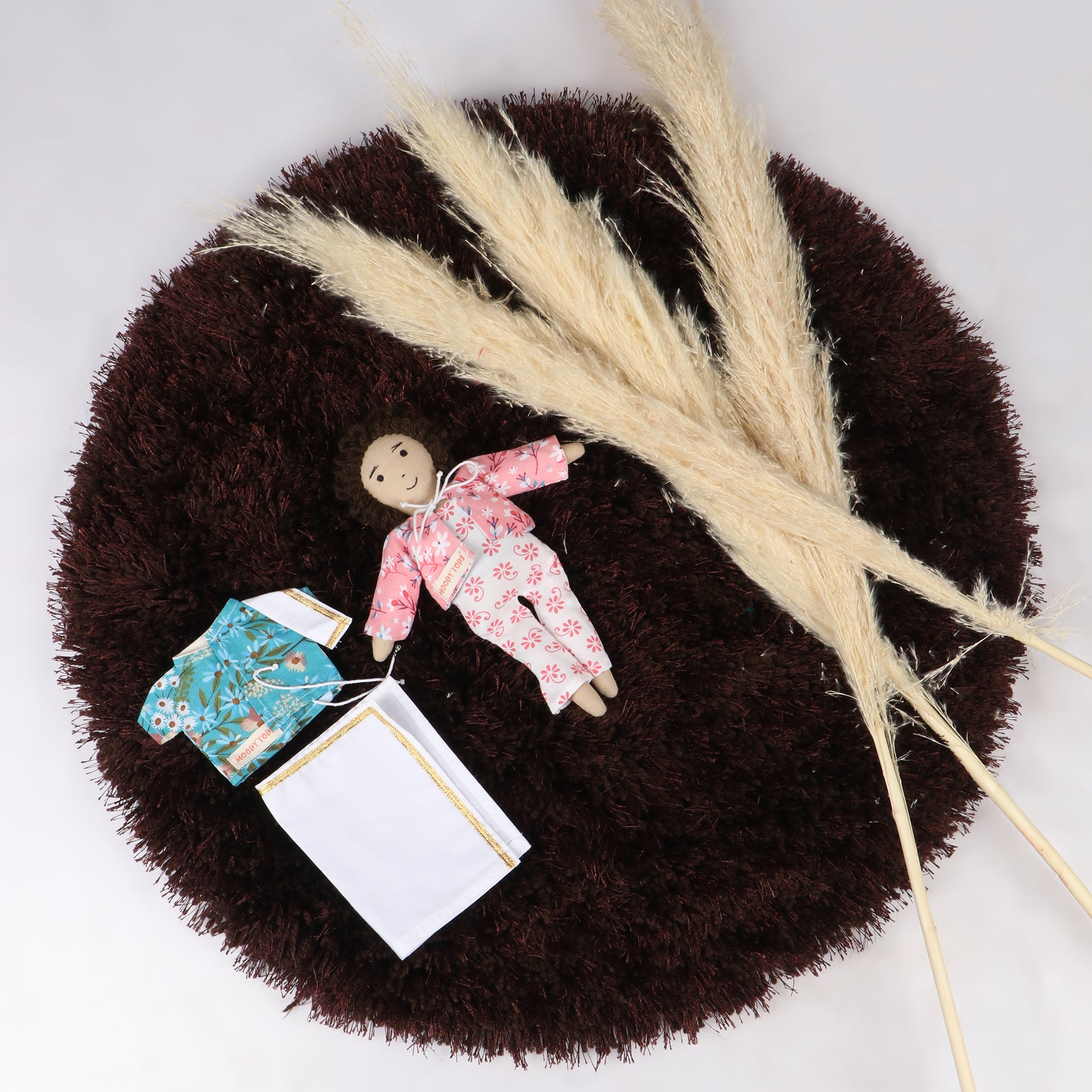Cute 9 inch boy rag doll with brown hair and pink colored outfit with interchangeable floral shirt, made from child-safe, soft fabric