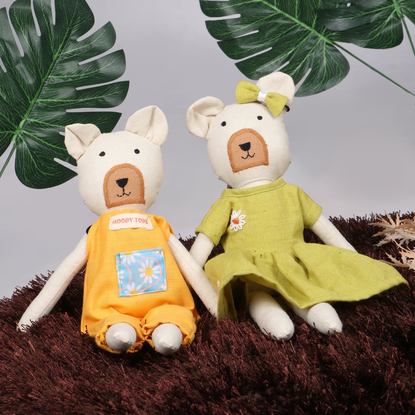 Pair of 12 inch soft fabric bear doll in sitting position wearing pastel green and orange colored outfit with leaves behind them, ideal for toddlers and young children