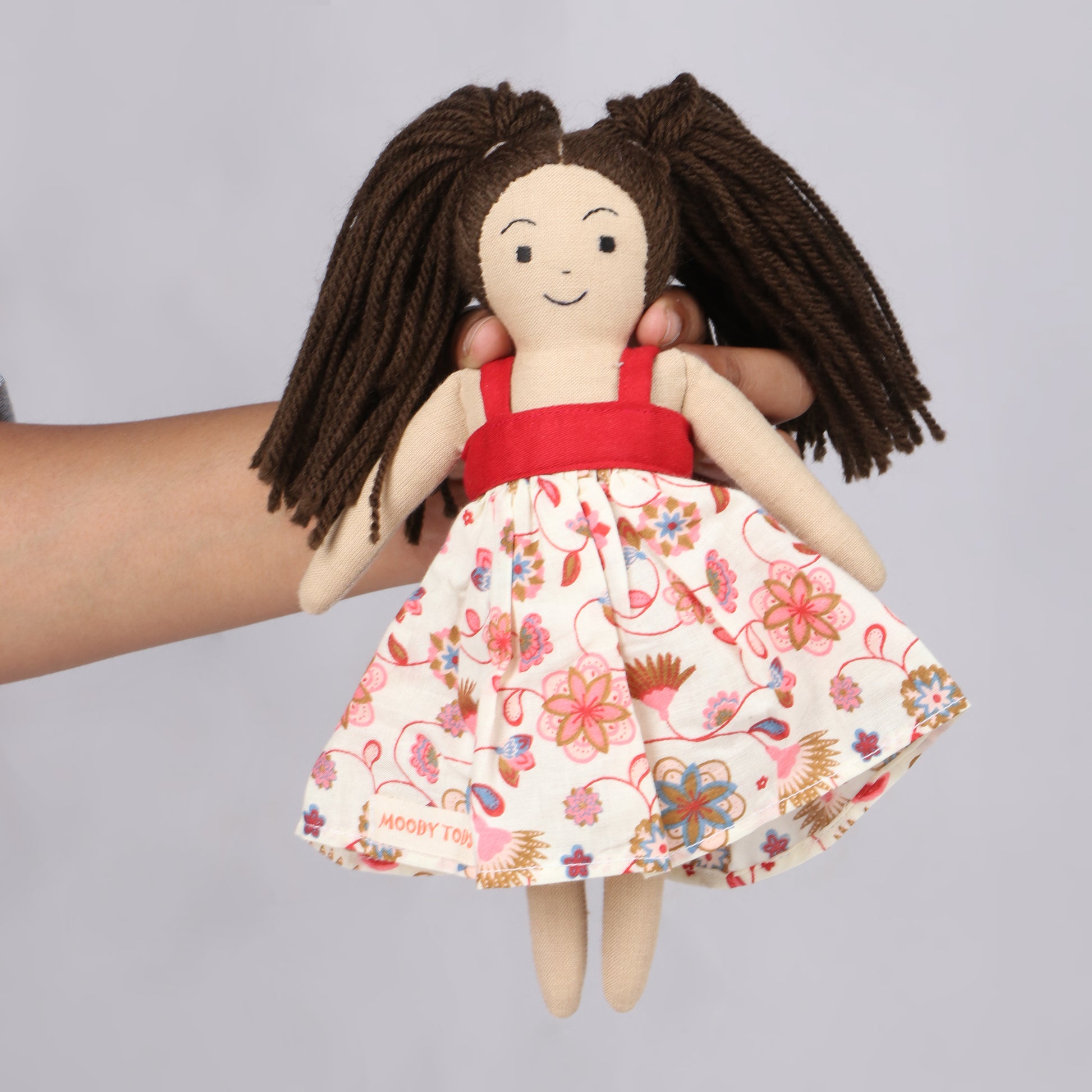 Holding a 9 inch handmade fabric rag doll with soft, sensory-friendly material, designed for comfort and imaginative play.