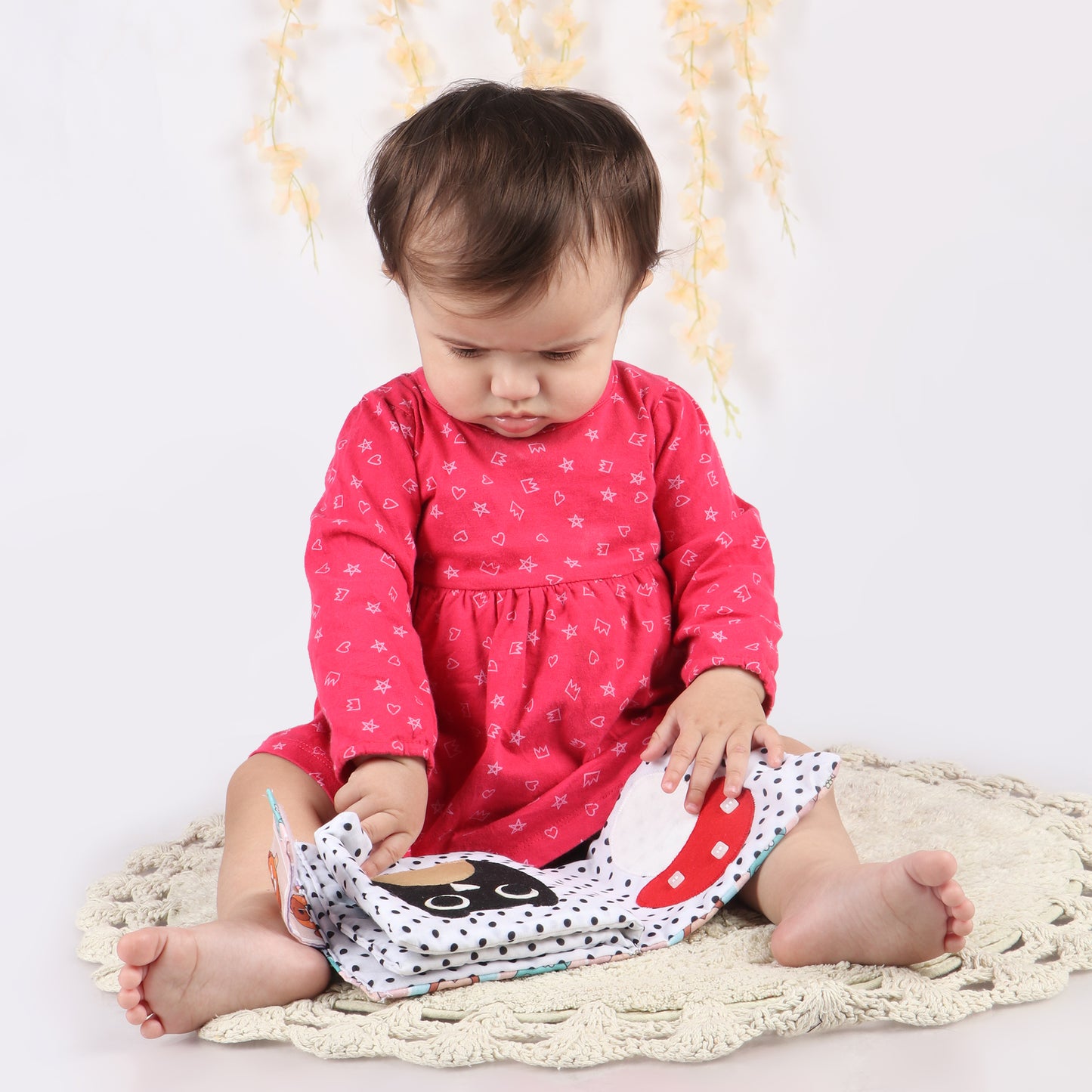 Toddler exploring soft sensory book with crinkly pages, bright colors, and touchable textures to engage young minds with animal print and child-friendly fabric