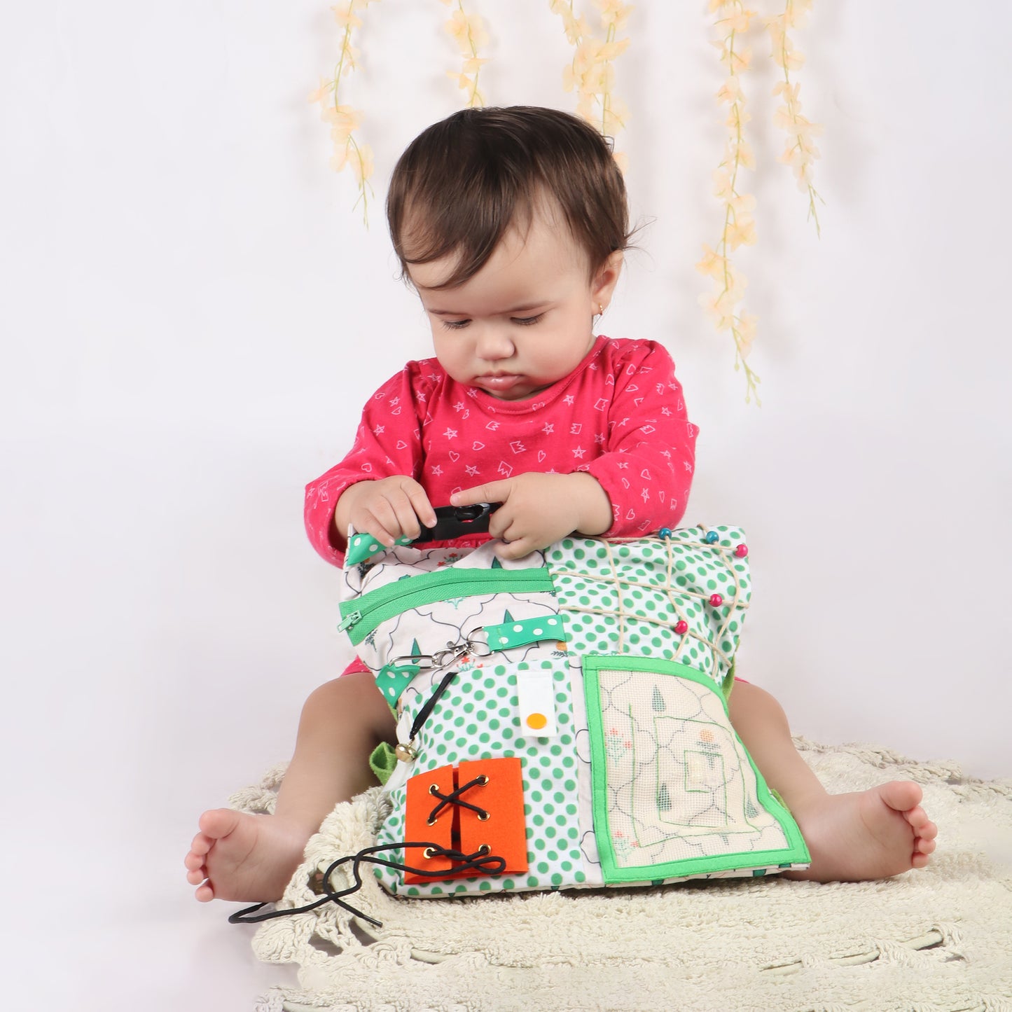 Toddler playing with buckle activity from sensory fidget blanket which is great for tactile stimulation and calm play