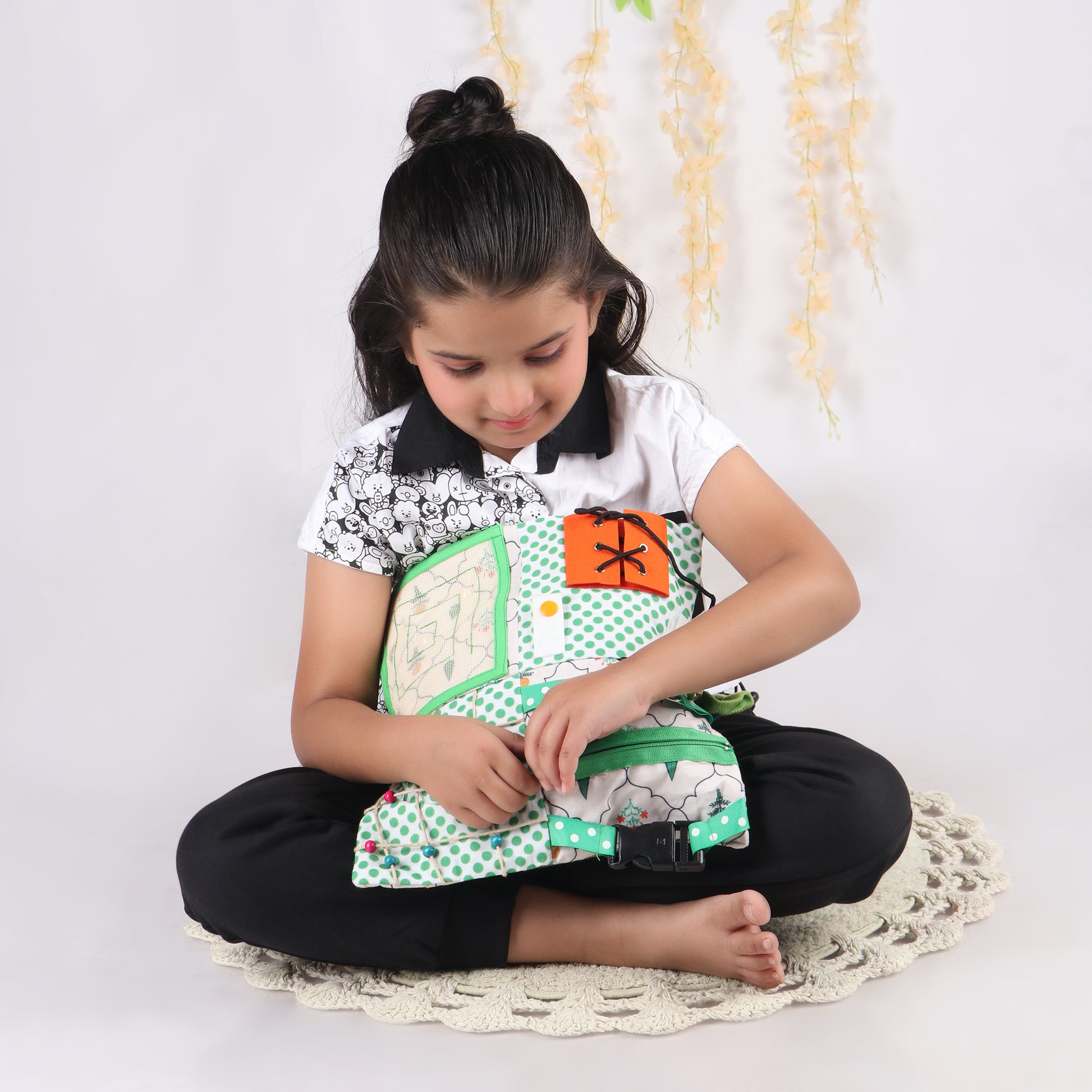 Young girl playing with zipper activity activity from sensory fidget blanket which is great for tactile stimulation and calm play
