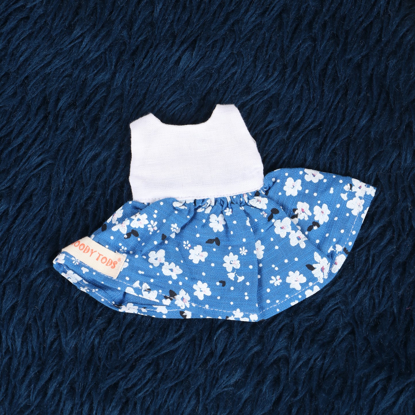 Close up of cute white and blue floral frock made from soft fabric, child-friendly for 7 inch girl rag doll