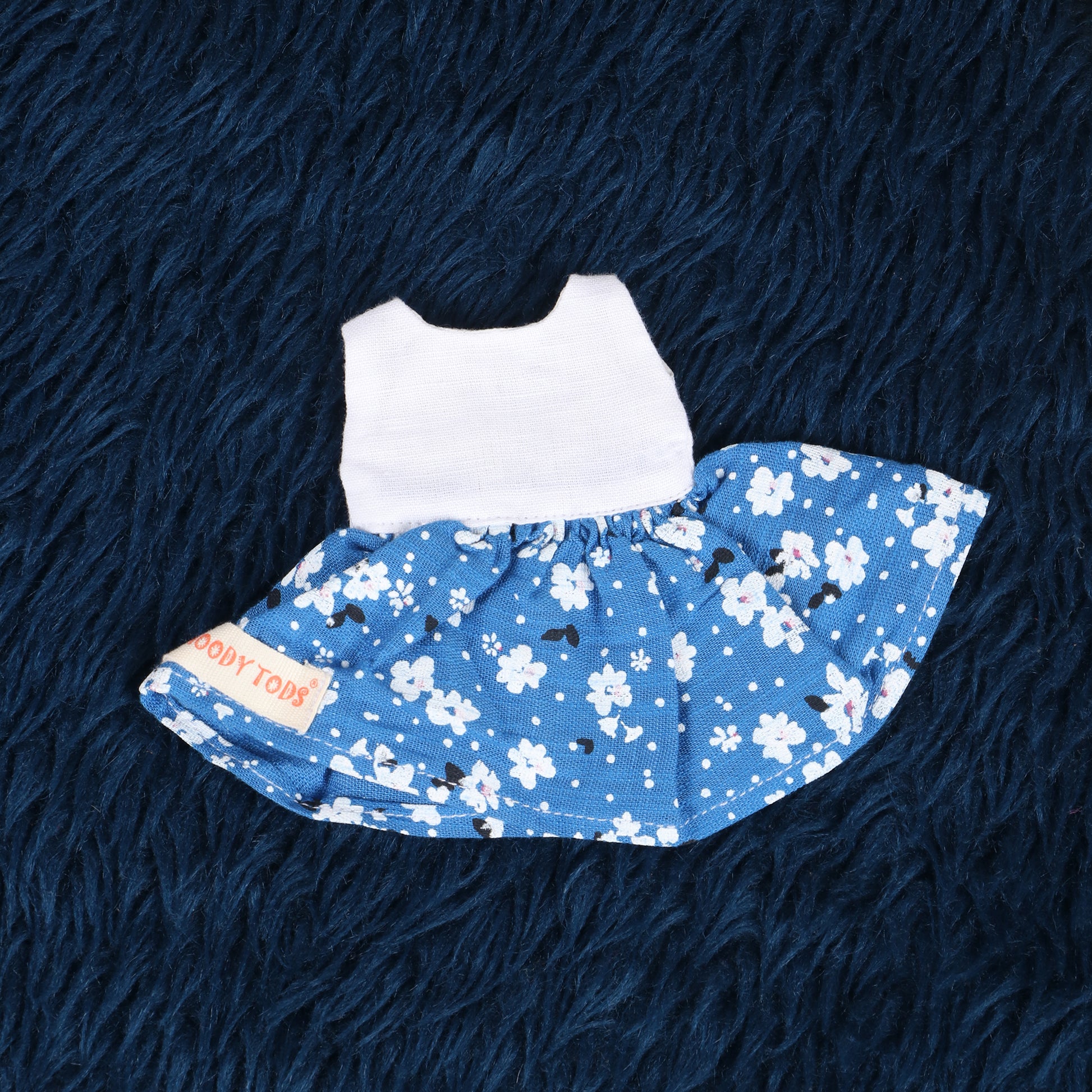 Close up of cute white and blue floral frock made from soft fabric, child-friendly for 7 inch girl rag doll