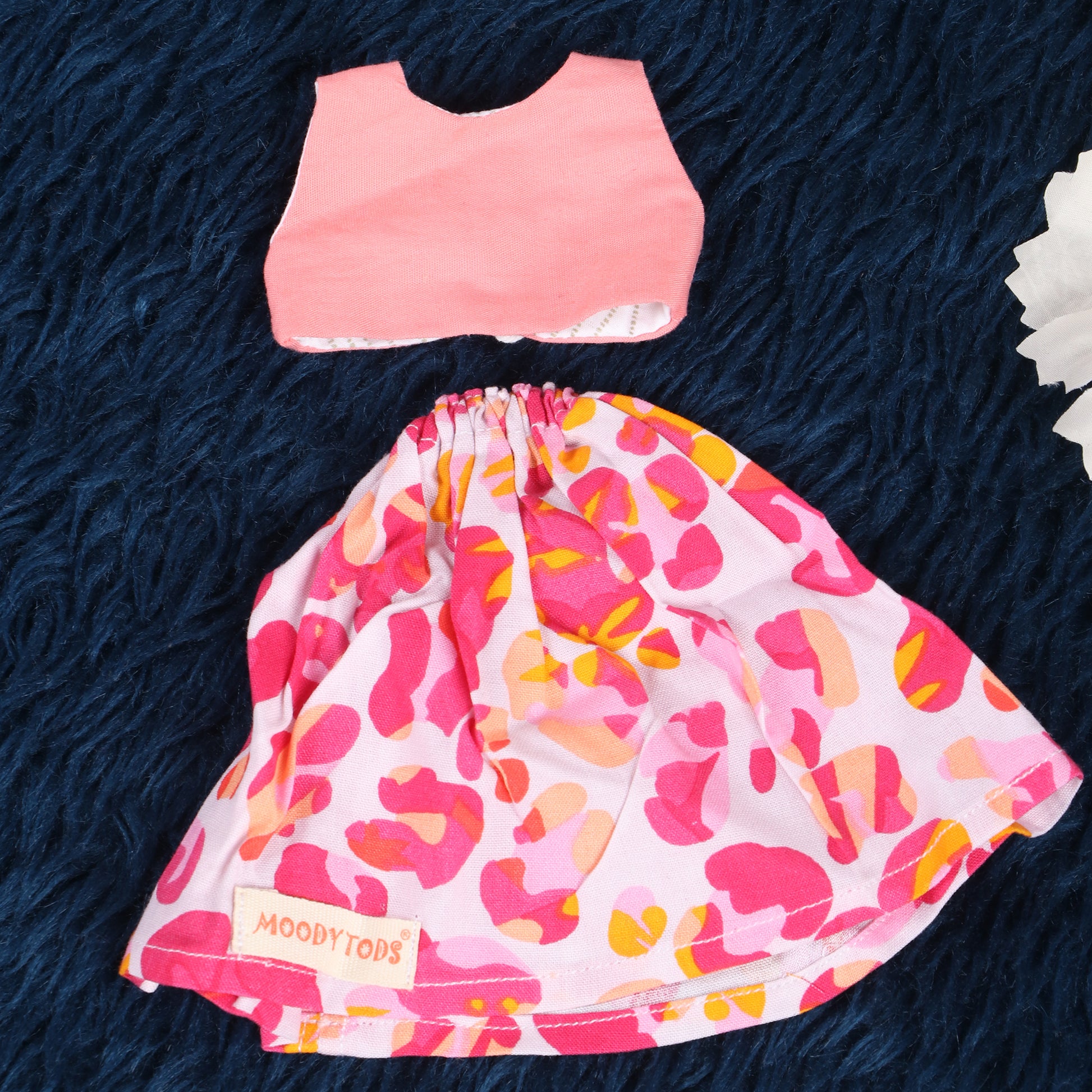 Close up of cute handmade pink floral frock for 9 inch girl rag doll made with soft, sensory-friendly material