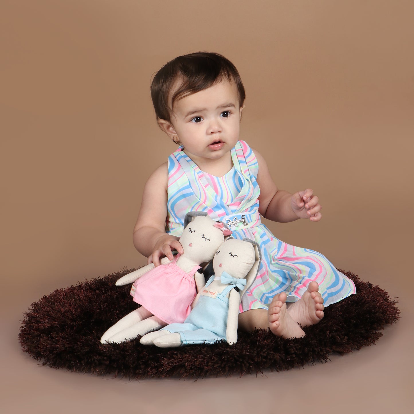 Toddler holding pair of adorable 12 inch plush bunny toy demonstrating its child-friendly size and comfort