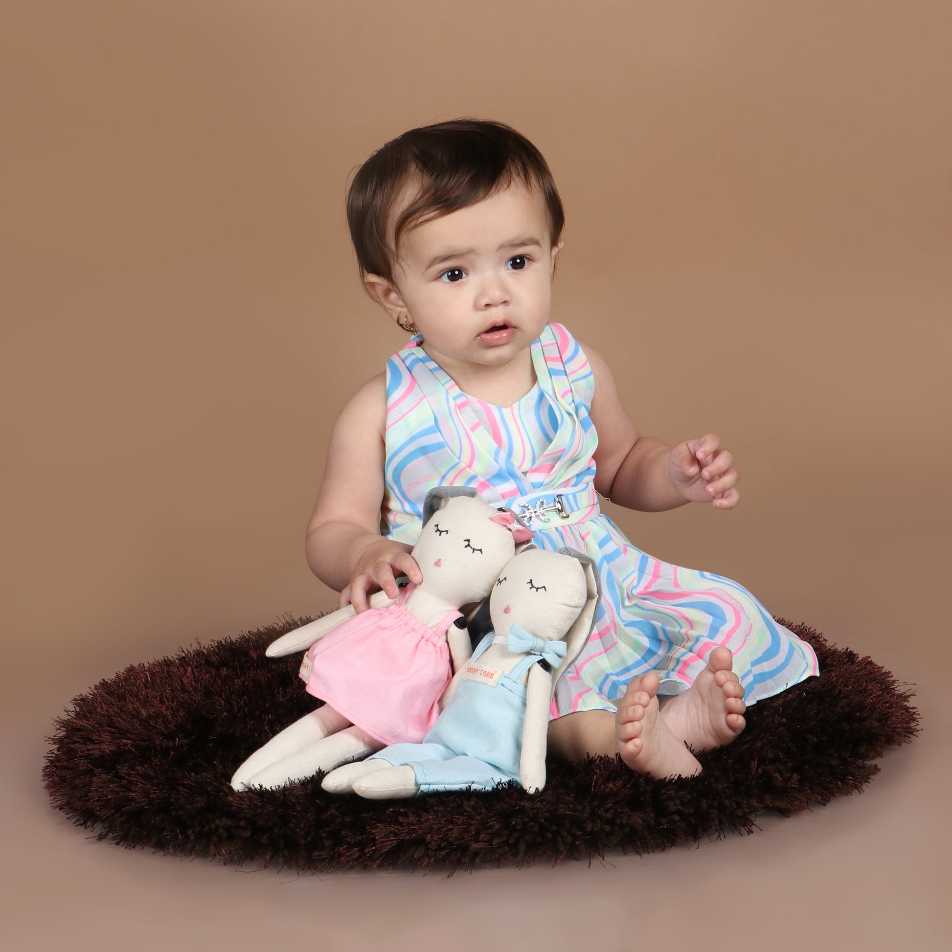 Toddler holding pair of adorable 12 inch plush bunny toy demonstrating its child-friendly size and comfort