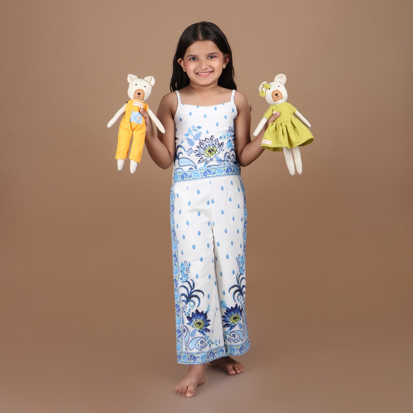 Little girl holding pair of 12 inch soft fabric bear doll in both hands demonstrating its child-friendly size, and comfort