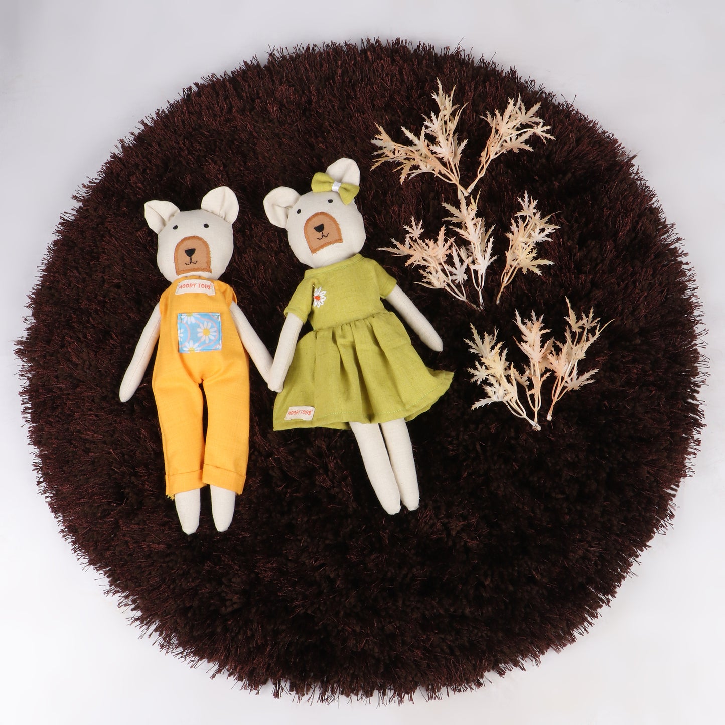 Pair of 12 inch soft fabric bear doll lying flat on brown rug wearing pastel green and orange colored outfit, ideal for toddlers and young children