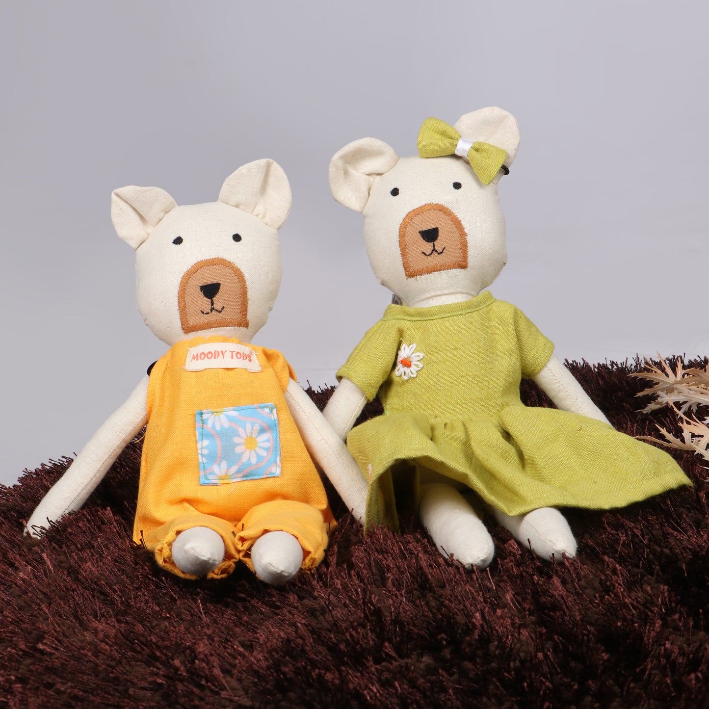 Pair of 12 inch soft fabric bear doll in sitting position wearing pastel green and oranage colored outfit, ideal for toddlers and young children