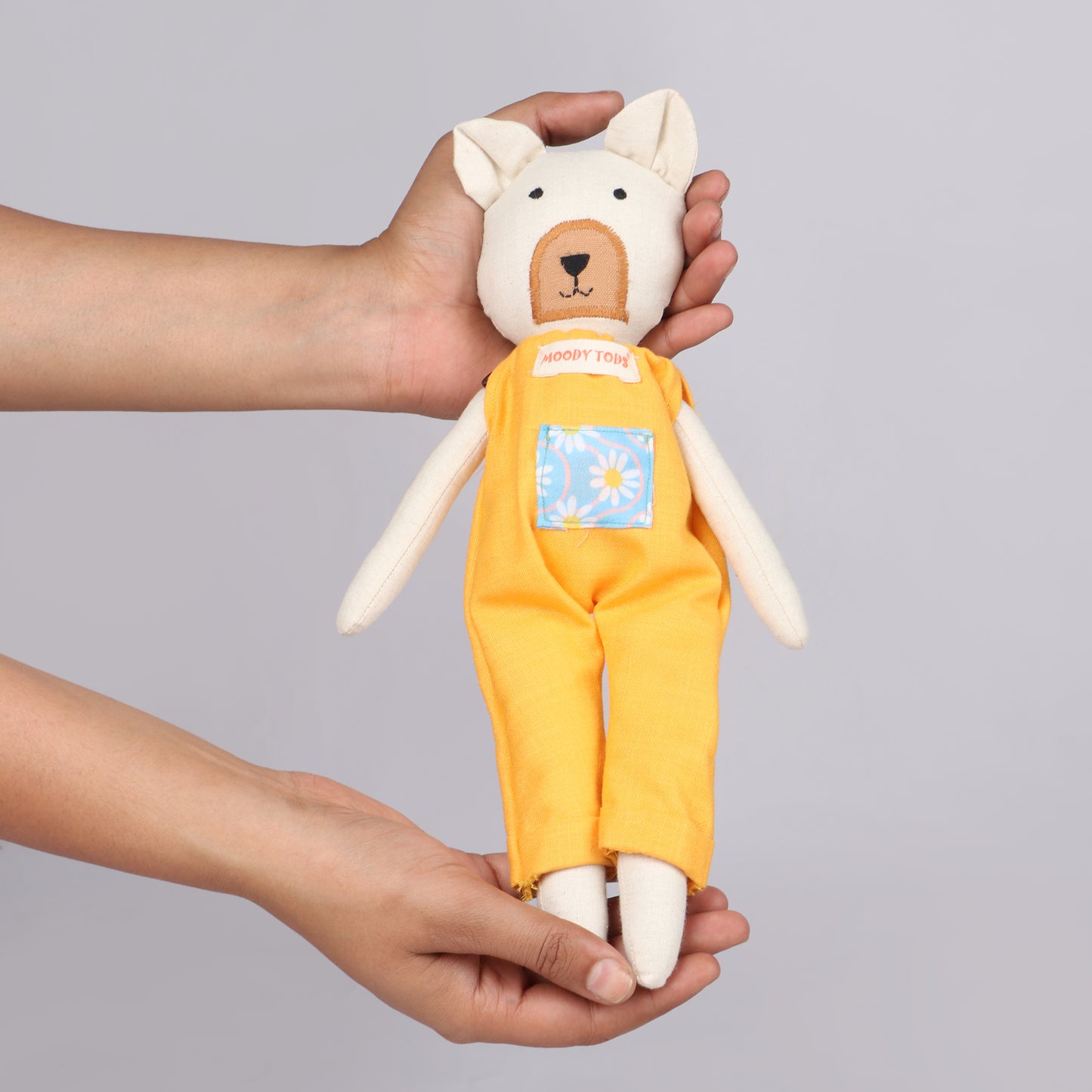 Holding a 12 inch soft fabric bear doll in hands wearing pastel orange colored outfit, ideal for toddlers and young children